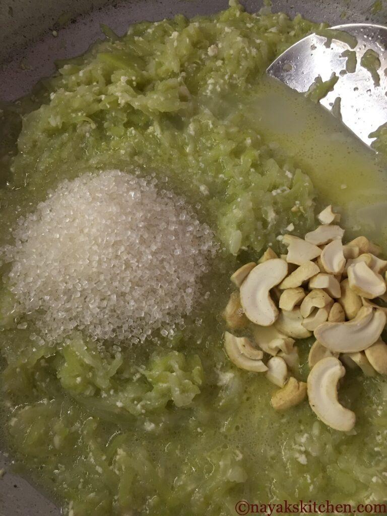 Adding sugar and cashewnuts to cooked dudhi