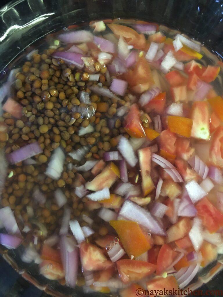 Cooking masoor with finely chopped oinion and tomato