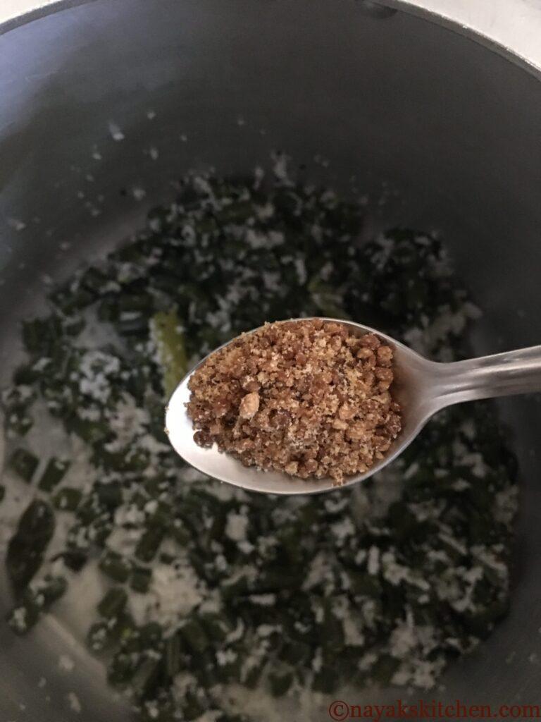 Adding jaggery to val papdichi bhaji