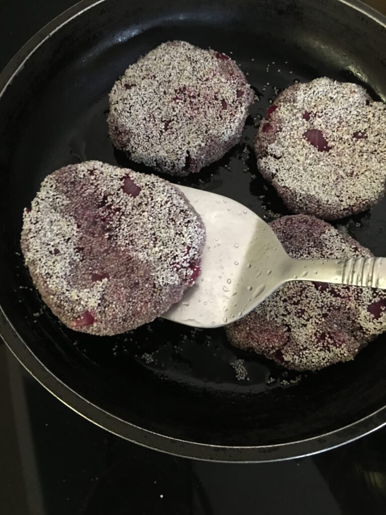 Turning beetroot cutlets to fry other side.