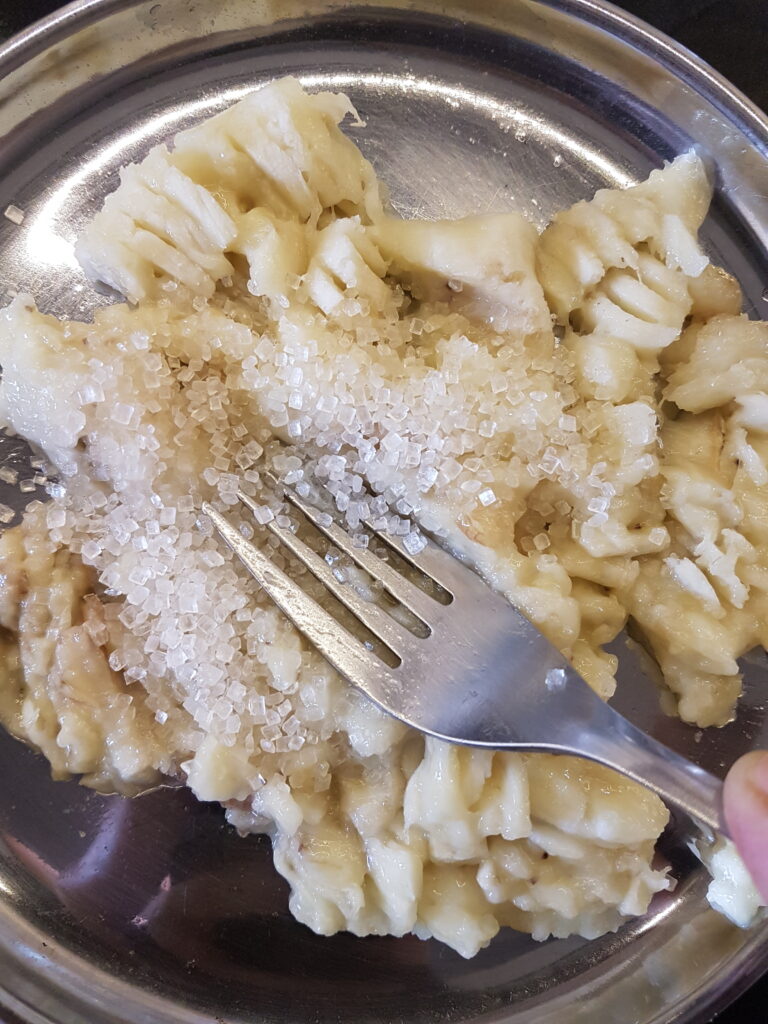 Mashing bananas with a fork along with sugar