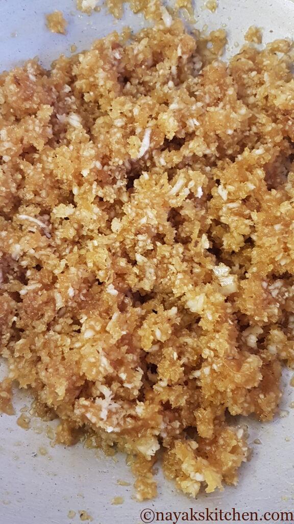 Mixing coconut and jaggery well