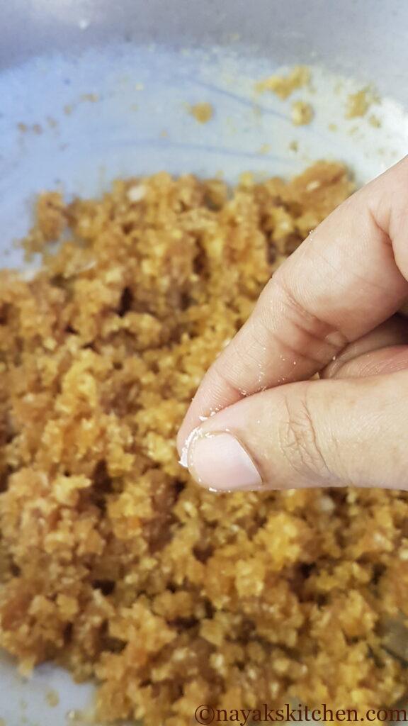 Adding salt to coconut jaggery mixture for patoli recipe