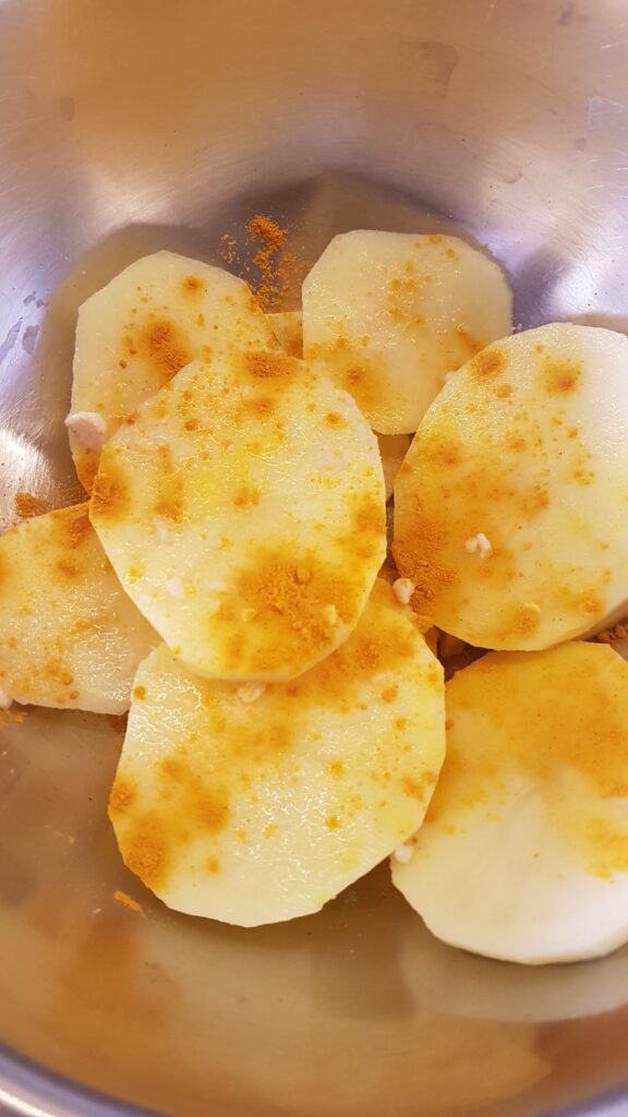 Adding turmeric to batat fodi