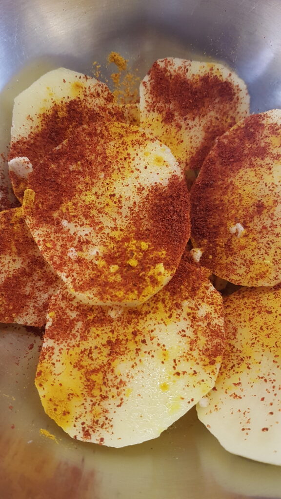 Adding chilli powder to batat fodi