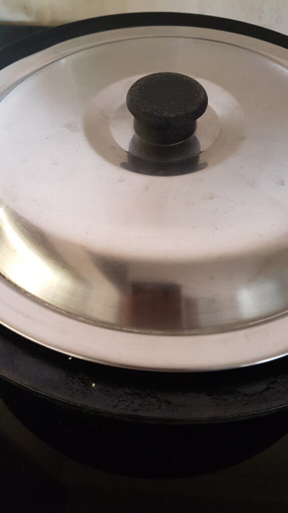 Covering with a lid to cook batat fodi