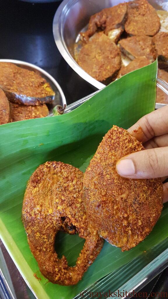 Placing kingfish in banana leaves for storing