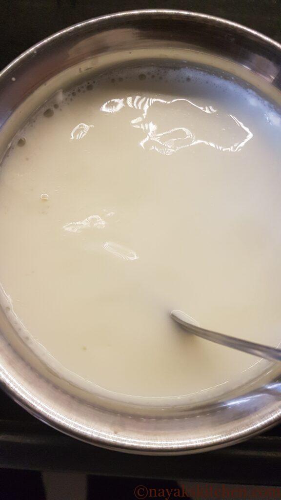 Stirring milk to uniformly mix the starter