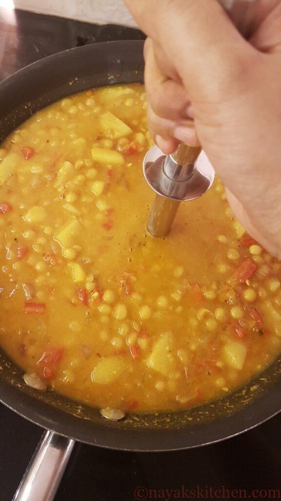 Mashing white peas-potato mixture