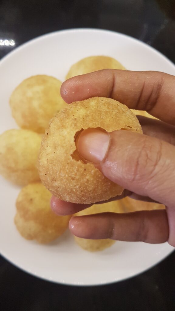 Piercing a hole in the centre of the puri