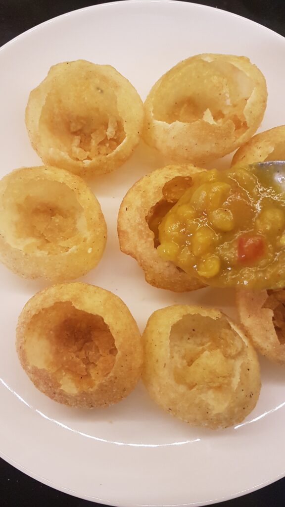 Adding ragda to puffed puri