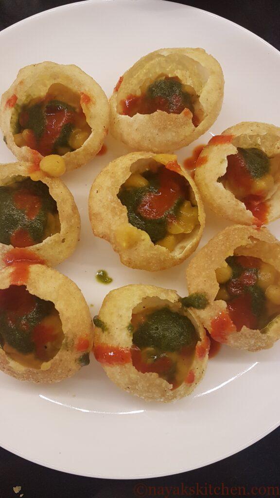 Adding red chutney to puri