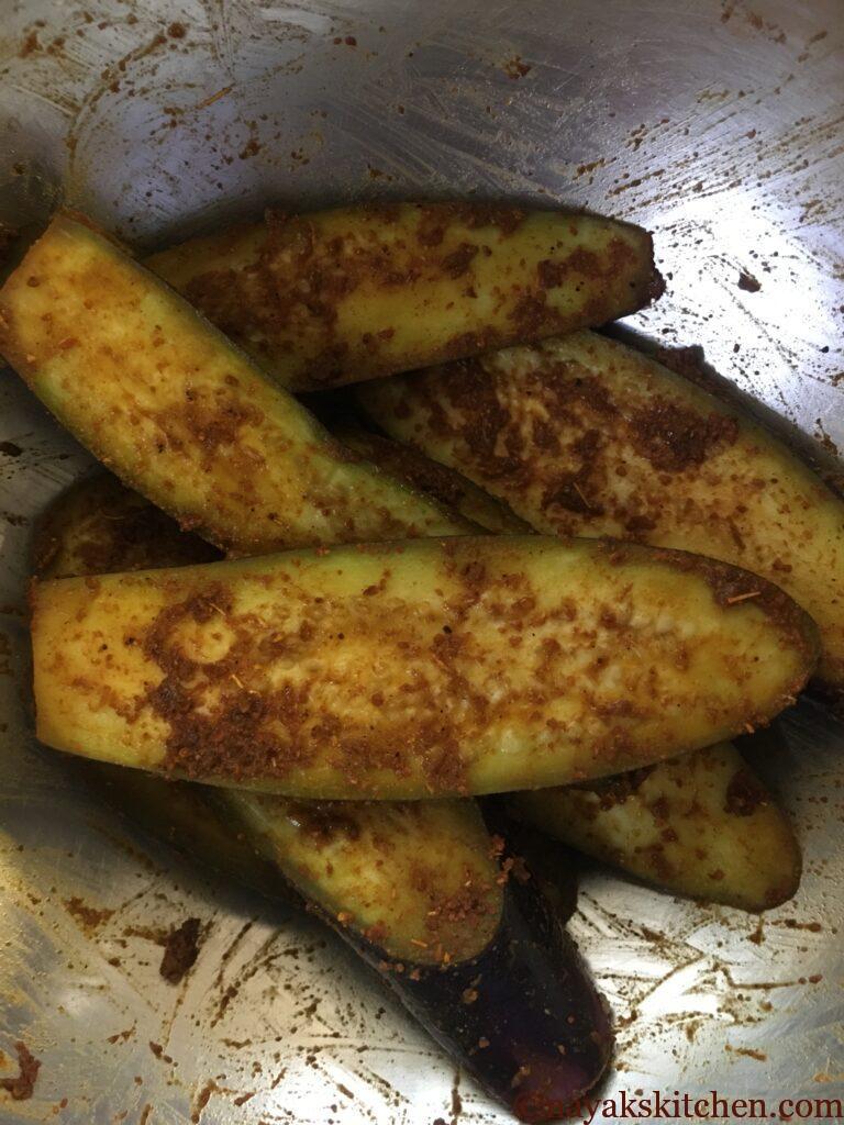 Coating brinjal pieces with spices