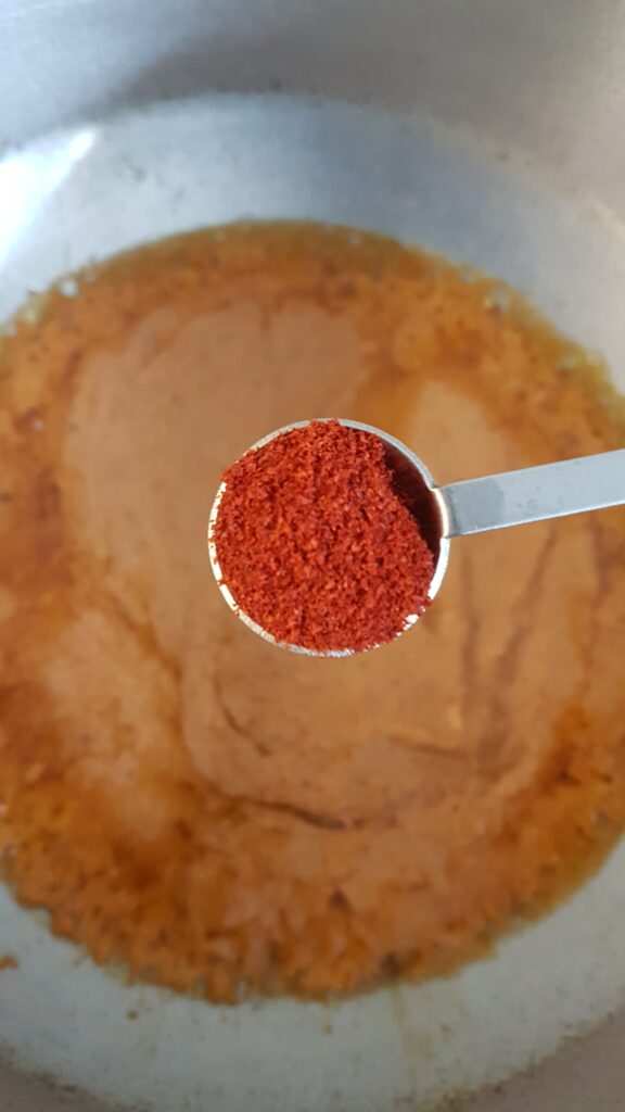 Adding Kashmiri chilli powder
