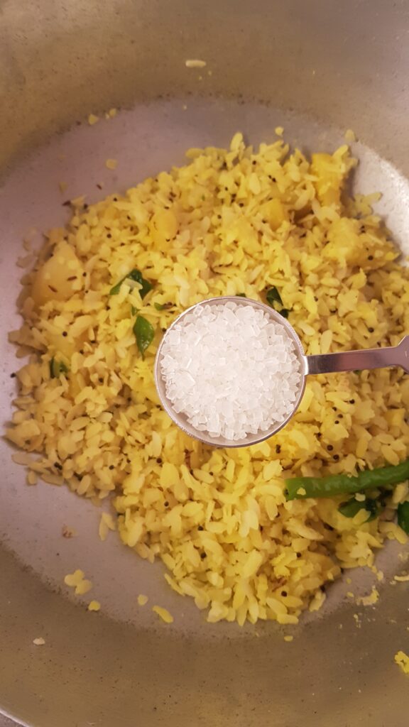 Adding sugar to potato poha