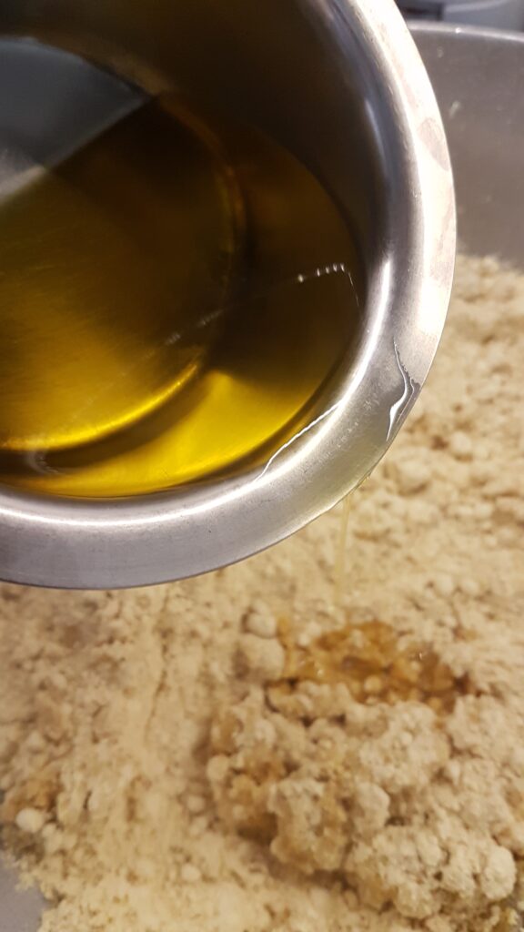 Adding warm ghee to roasted besan flour