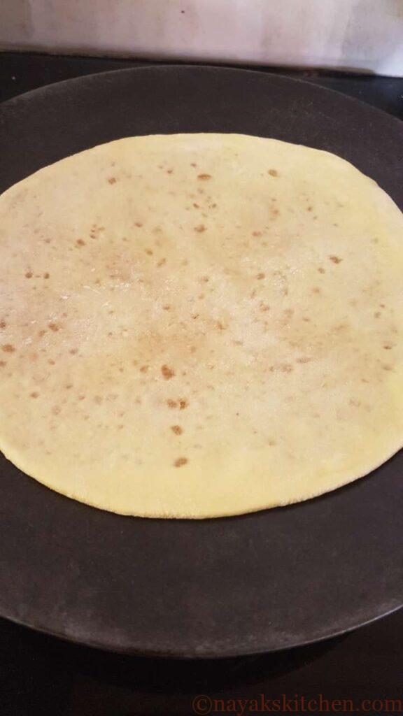 Frying the puran poli on a tava