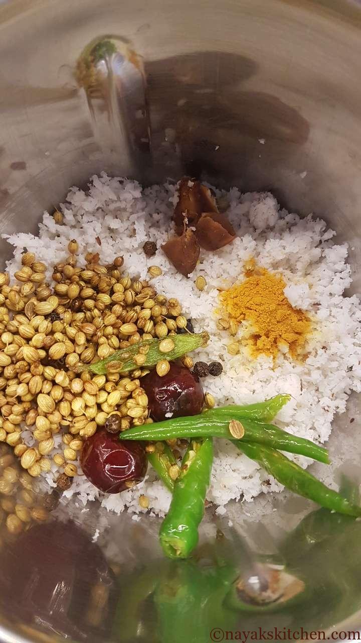 Grated coconut, tamarind, turmeric and spices in a mixie jar