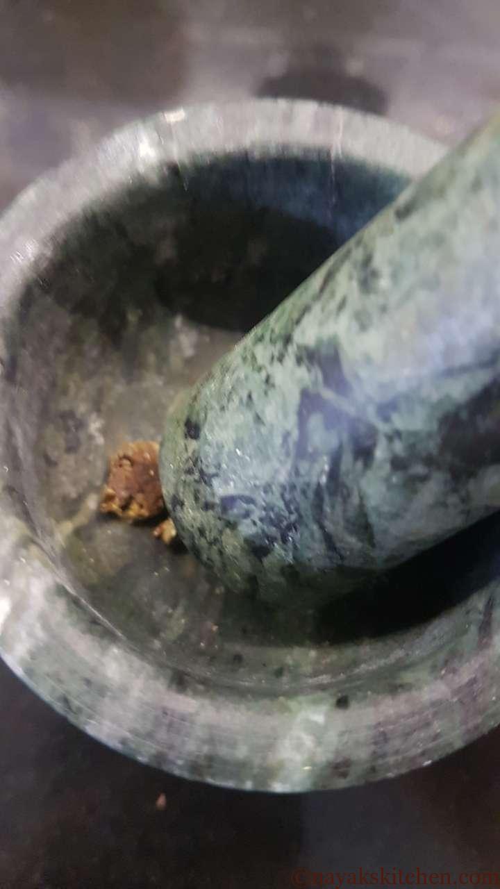 Making powder of hing in a mortar and pestle