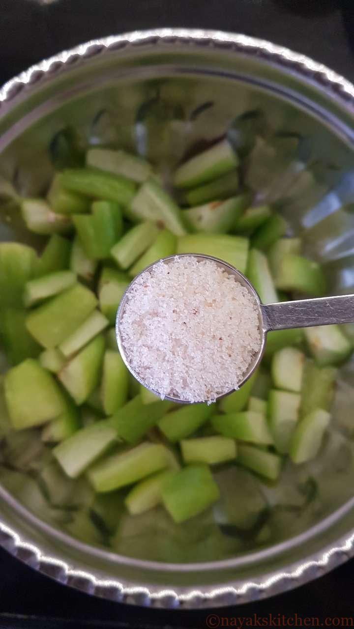 Adding salt to chopped bilimbi