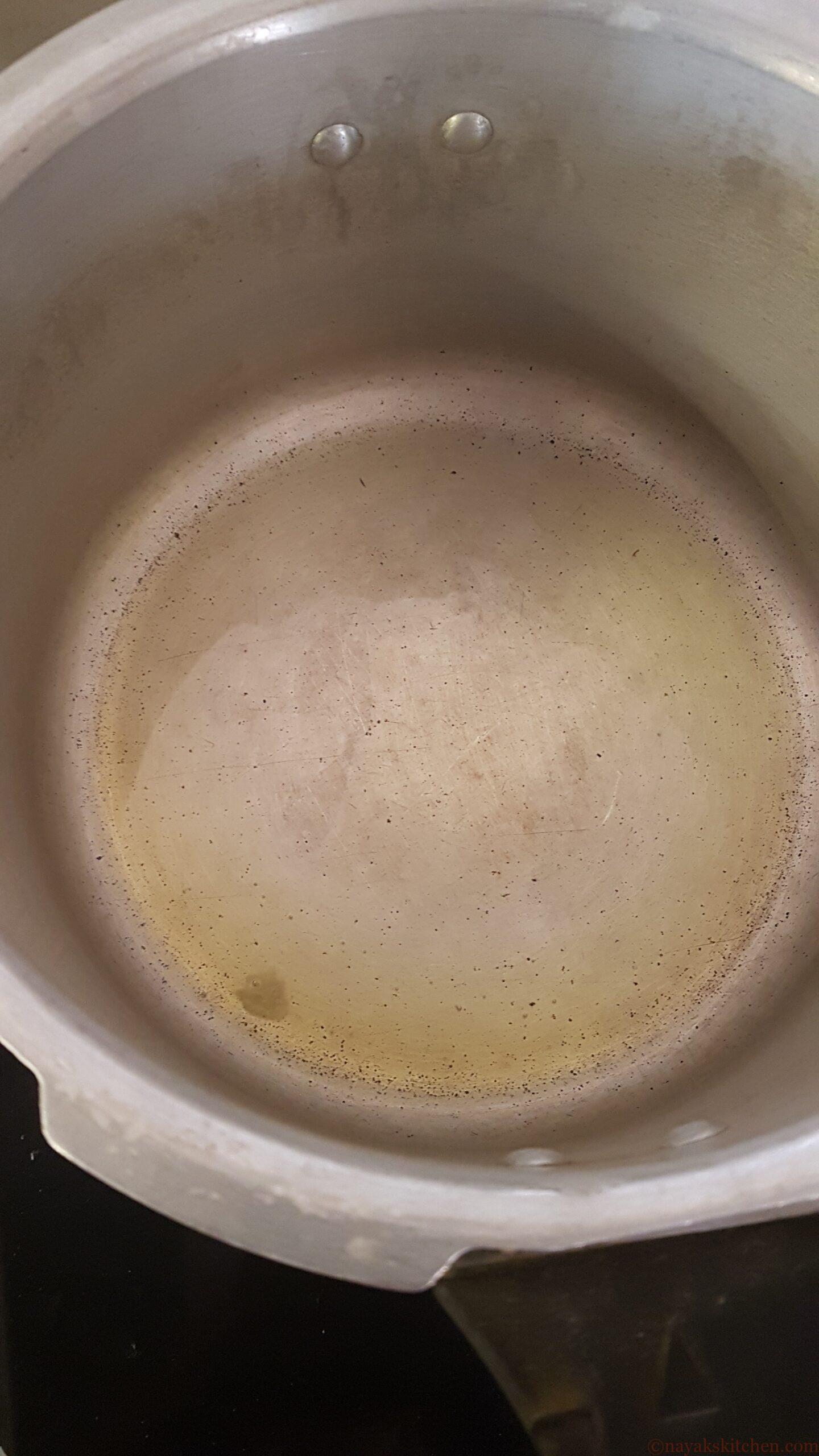 Greasing the pressure cooker with ghee