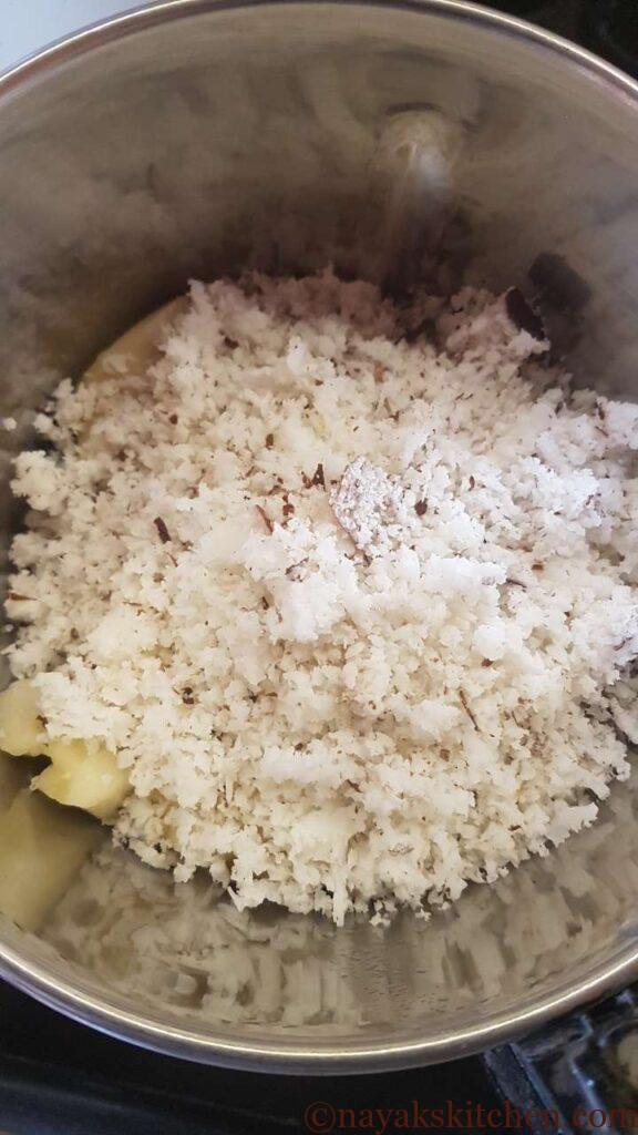Adding grated coconut to jackfruit