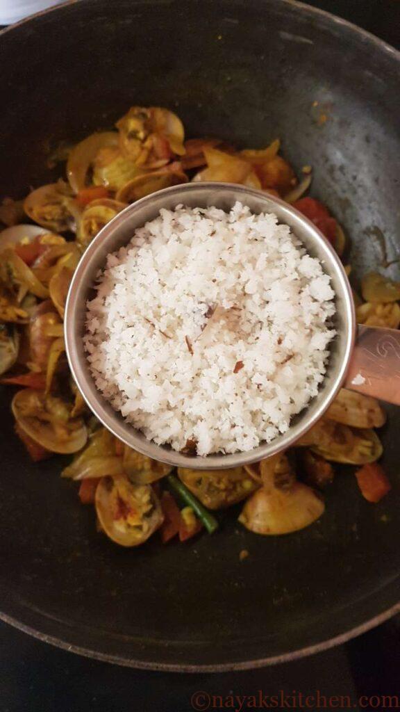 Adding freshly grated coconut to tisreo sukhem