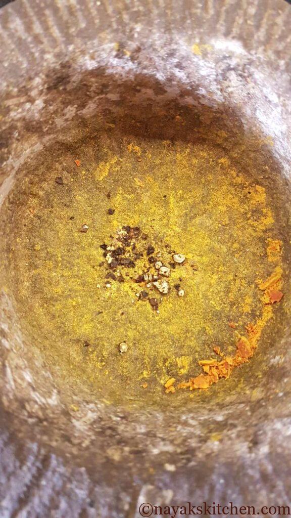 Crushed black pepper in a mortar and pestle