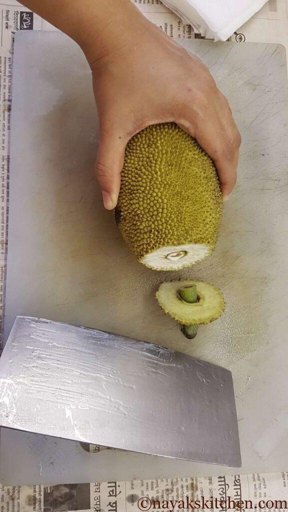 (How to cut a raw jackfruit?) Chop off the front part of the tender jackfruit