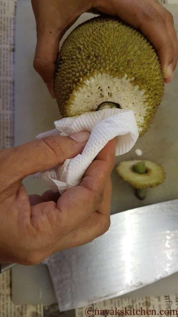 (How to cut a raw jackfruit?) Cleaning the oozing sap with a tissue