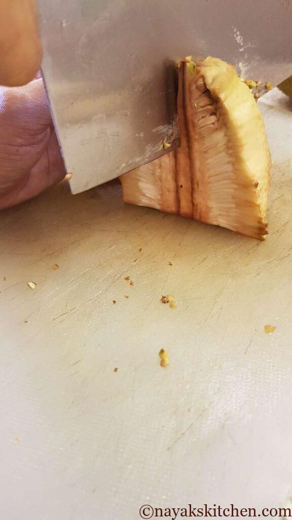 (How to cut a raw jackfruit?) Cutting the raw jackfruit from the centre
