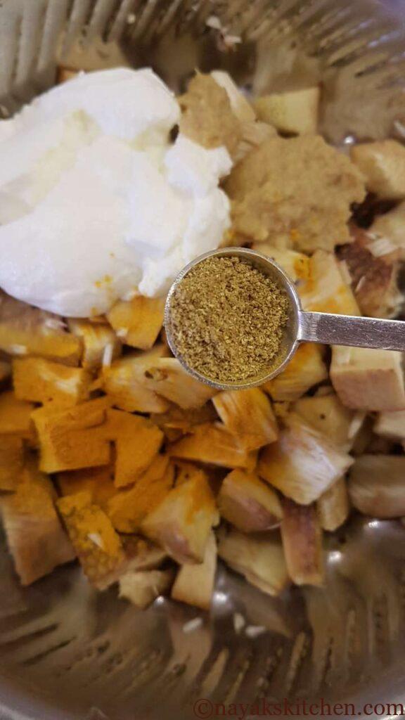 Adding coriander powder to jackfruit pieces