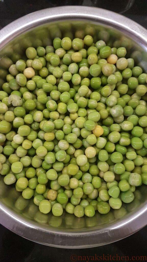 Draining the water from green peas