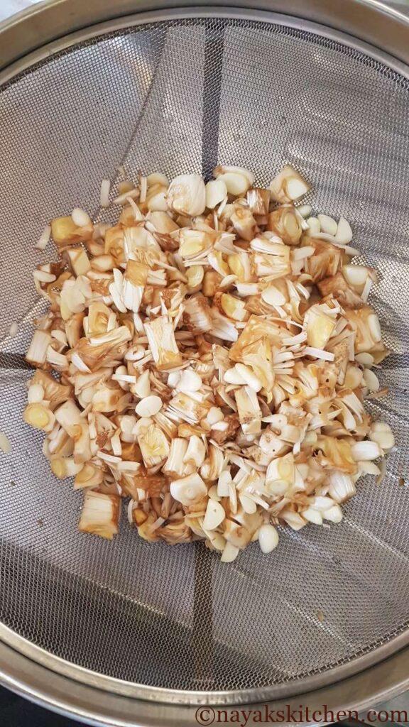 Draining the water from raw jackfruit