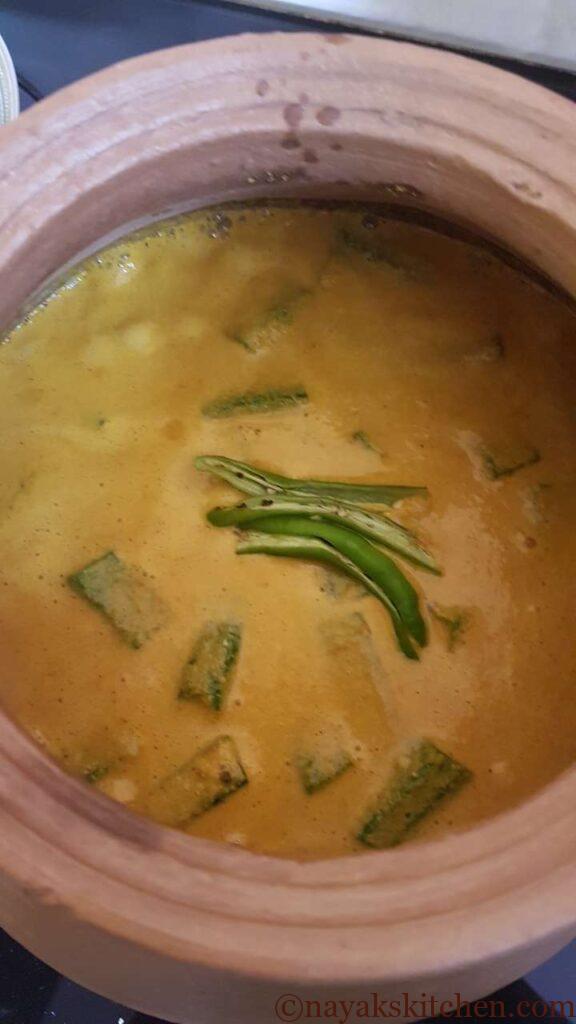 Adding slit green chillies to goan prawn curry recipe