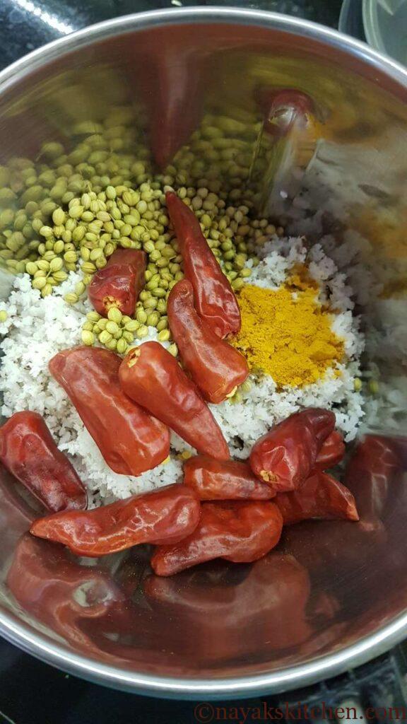 Grinding spices and grated coconut in a mixie
